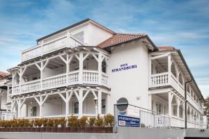 un bâtiment blanc avec un panneau sur son côté dans l'établissement Fewo Auszeit im Haus Strandburg, à Binz