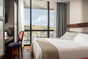 圣马力诺Welcome Hotel的一间带床和大窗户的酒店房间