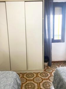 een slaapkamer met een kast en een tegelvloer bij Valencia Well Located Shared Apartment in Valencia