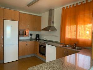 uma cozinha com um frigorífico branco e um lavatório em Villa Victoria em L'Ampolla