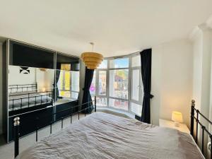 1 dormitorio con cama y ventana grande en Spacious and Bright Apartment en Londres