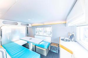 Habitación pequeña con mesa y banco en un tren en glampark FREE AND EASY CAMP RESORT　三重県, en Komono