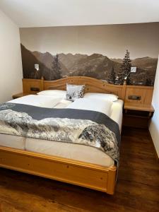 ein Schlafzimmer mit einem großen Bett mit einem Wandbild der Berge in der Unterkunft Engels Landhaus in Oberstdorf
