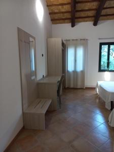 - une chambre avec un lit, un bureau et un lavabo dans l'établissement Agriturismo Villa Degli Ulivi, à San Vero Milis