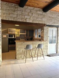 uma cozinha com dois bancos de bar e um balcão em Bel appartement proche du centre ville em Montpellier