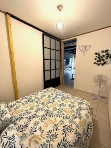 um quarto com uma cama com um cobertor branco e azul em Bel appartement proche du centre ville em Montpellier