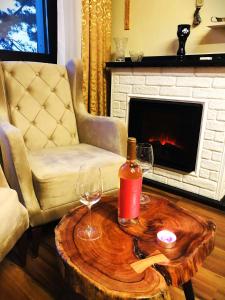 soggiorno con sedia e tavolo con bottiglia e bicchieri di Flat Veiras in Five Star Maxi Hotel and Spa a Velingrad