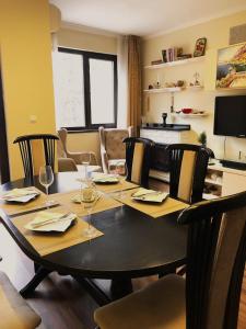una sala da pranzo con tavolo e bicchieri da vino di Flat Veiras in Five Star Maxi Hotel and Spa a Velingrad