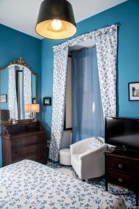 a bedroom with blue walls and a bed and a mirror at B&b Isabel in Salerno