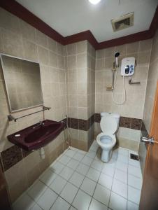 ein Bad mit einem WC und einem Waschbecken in der Unterkunft Wings Grand Orchard Hotel in Kuala Lumpur