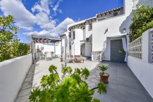 a white house with a patio with plants at Rafol - Casa adosada con piscina comunitaria y tenis comunitario in Calpe