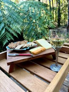 uma mesa de madeira com um copo de vinho e queijo em Tranquil getaway amidst nature in Icy Creek em Fumina