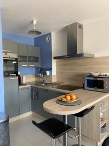 a kitchen with a table with a plate of fruit on it at Charmant appartement à l'entrée de Sauzon in Sauzon