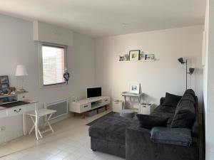 a living room with a couch and a desk at Charmant appartement à l'entrée de Sauzon in Sauzon