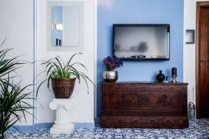 a living room with a tv on a blue wall at B&b Isabel in Salerno