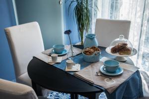 une table avec des tasses et des assiettes de nourriture dans l'établissement B&b Isabel, à Salerne