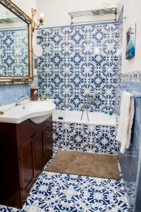 a blue and white bathroom with a sink and a tub at B&b Isabel in Salerno