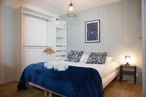 a bedroom with a bed with a blue blanket at Petit Moret - Cœur de ville in Moret-sur-Loing
