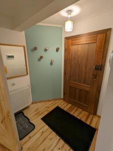 een kamer met een houten deur en een zwart tapijt bij Walimka in Walim
