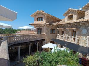 Edificio grande con balcón y puente en Hotel Rural El Cañón del Duratón en Sepúlveda