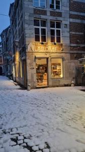 un negozio in una strada con la neve per terra di Chambres d'Hôte Alarome a Huy