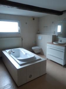 ein Badezimmer mit einer Badewanne, einem Waschbecken und einem WC in der Unterkunft Chambres d'Hôte Alarome in Huy