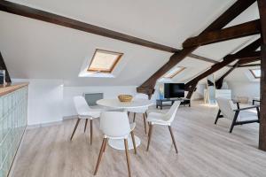 a dining room with a white table and chairs at LE NID DE LA GLORIETTE Hyper centre NANTES WIFI in Nantes