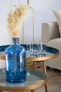 un vase bleu et deux verres sur une table dans l'établissement LE NID DE LA GLORIETTE Hyper centre NANTES, à Nantes