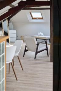 une salle à manger avec une table et des chaises blanches dans l'établissement LE NID DE LA GLORIETTE Hyper centre NANTES, à Nantes