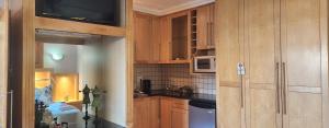 a kitchen with wooden cabinets and a microwave at The Wooden Leg Guesthouse in Kleinmond
