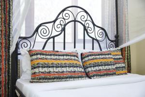 a bed with a black headboard and two pillows at Villa Viva Tanzania in Arusha