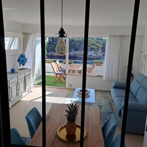 uma sala de estar com um sofá azul e uma mesa em Appartement Ferrera Park 408 vue mer em Cala Ferrera