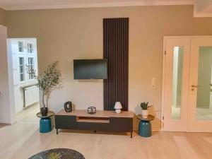 ein Wohnzimmer mit einem Couchtisch und einem Flachbild-TV in der Unterkunft Villa Augusta am Kurpark Apartment 7 in Bad Salzuflen