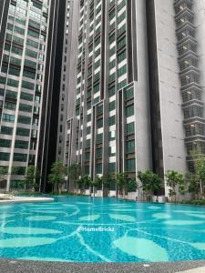 une grande piscine bleue en face d'un bâtiment dans l'établissement Bangsar South Botanical I Bed & Pillow, à Kuala Lumpur