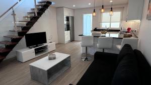 a living room with a couch and a tv and a kitchen at VCS House by Madeira Holiday in Funchal