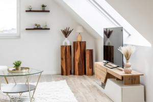 a living room with a tv and a glass table at Roof-Suite 01 I Aufzug I BBQ I WiFi I Balkon I TV in Rheda-Wiedenbrück