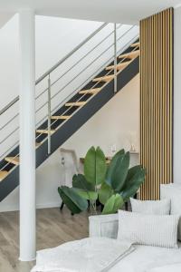 a living room with a staircase and a table and chairs at Roof-Suite 01 I Aufzug I BBQ I WiFi I Balkon I TV in Rheda-Wiedenbrück