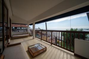 a room with a balcony with a view of the ocean at Dickwella Resort and Spa in Dickwella