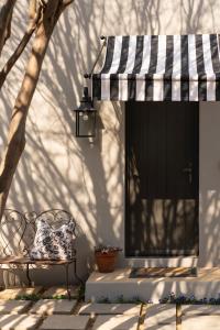 a bench sitting on a porch with a striped awning at Le Parc, Bryanston in Johannesburg