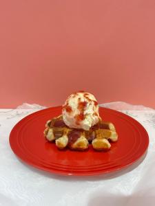 a waffle with ice cream on a red plate at Cafe&Hostel Kimi to Ichigo in Osaka