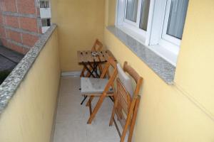 einen Tisch und Stühle auf einem Balkon mit Fenster in der Unterkunft Matias Lopez 78 in Sarria