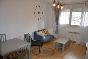 ein Wohnzimmer mit einem blauen Sofa und einem Tisch in der Unterkunft Matias Lopez 78 in Sarria
