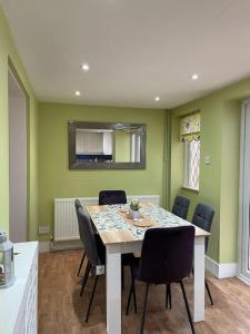 uma sala de jantar com mesa e cadeiras em Stylish 3 Bedroom House Basildon/Essex Upto 5 Guests em Basildon