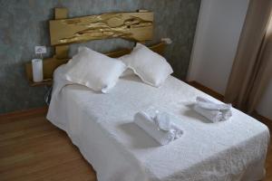 ein Schlafzimmer mit einem Bett mit weißen Handtüchern darauf in der Unterkunft Matias Lopez 78 in Sarria
