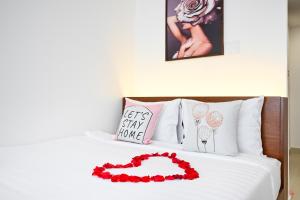 ホーチミン・シティにあるSaigon Hotel & Apartmentの白いベッド(赤い花付)