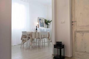 una sala da pranzo bianca con tavolo e sedie di ROSSENA HOME tranquillo appartamento, con giardino, vicino al centro ed all'Ospedale Santa Maria Nuova SMN a Reggio Emilia
