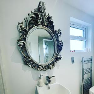 a mirror on a wall above a sink in a bathroom at Private Bright Bedroom with Ensuite River View in Kent