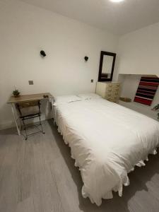 1 dormitorio con 1 cama blanca grande y escritorio en Private Bright Bedroom with Ensuite River View, en Kent