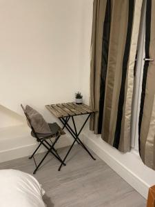 a small table and a chair in a room at Private Bright Bedroom with Ensuite River View in Kent