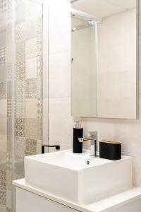 a bathroom with a white sink and a mirror at Apartamento de diseño con piscina y gimnasio By ElConserje in Murcia